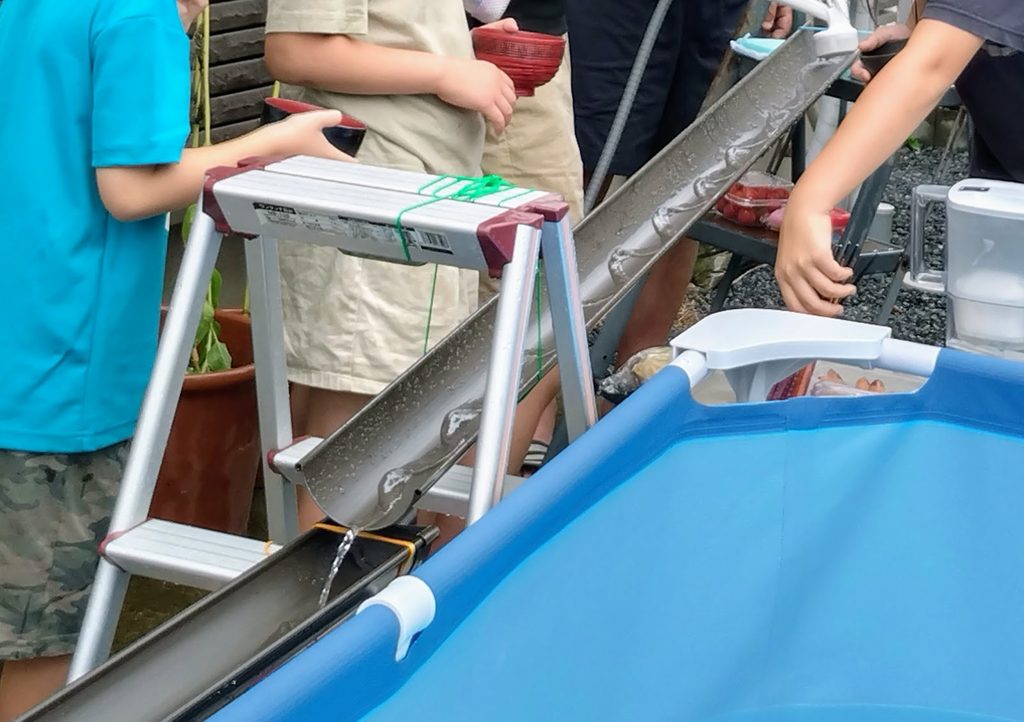 塩ビパイプで流しそうめんをしている写真