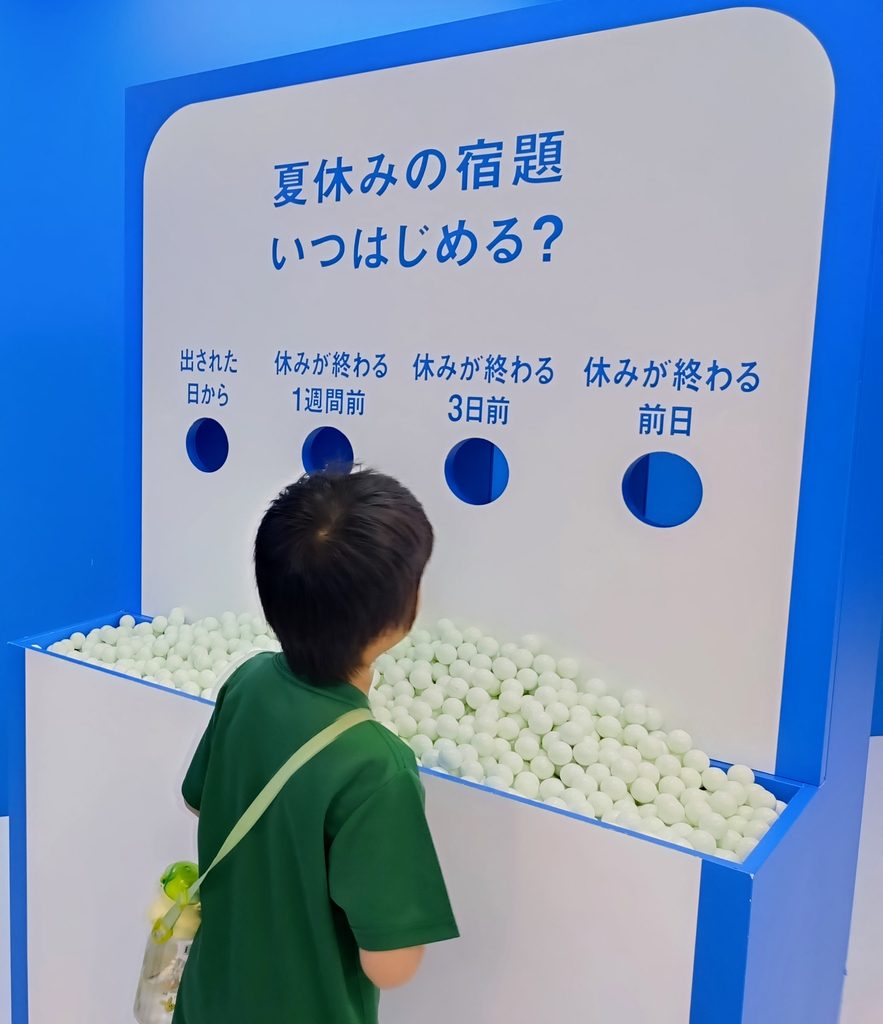 はてな展の質問を前に考え込む子どもの写真